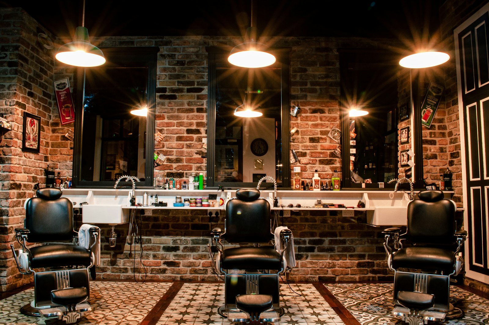 A black leather barber chair in front of a brick wall